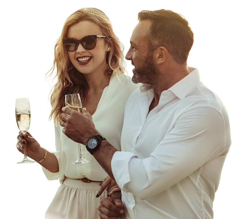 A couple raises their champagne glasses in a toast, enjoying a moment at The Parkstone by Trinity.