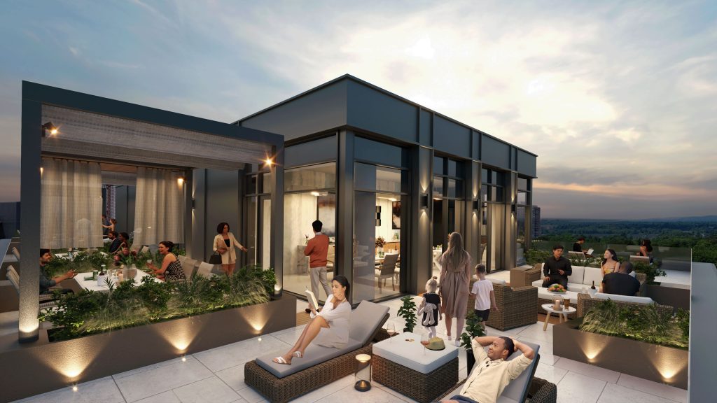 People and children relaxing on a rooftop terrace at night outside a modern apartment lounge.