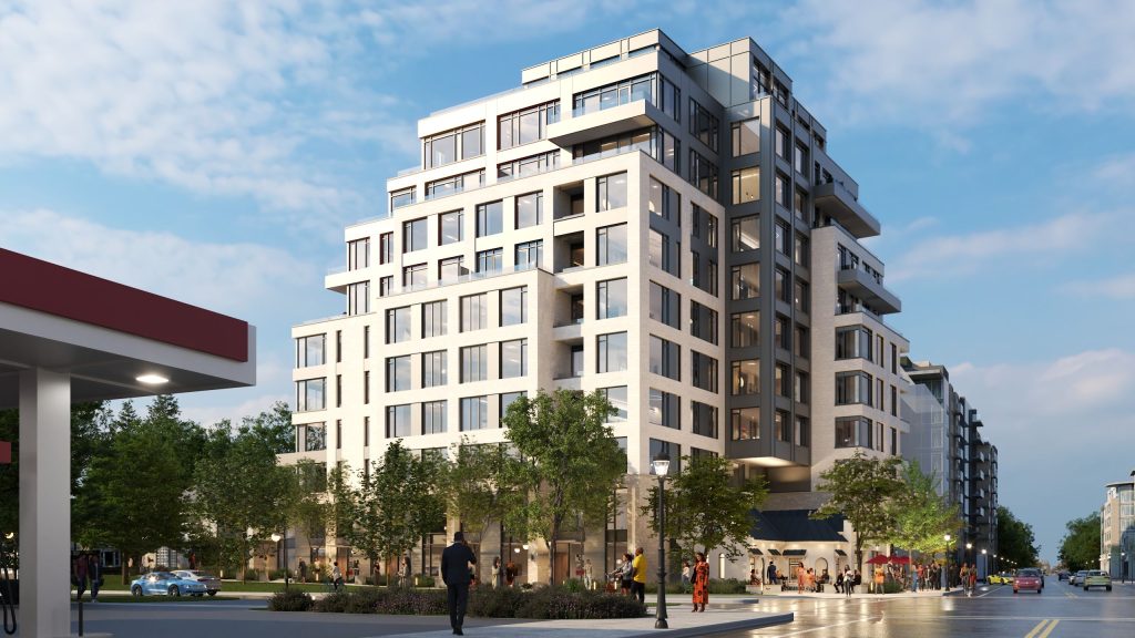 Neutral-coloured apartment building near a gas station with people on the sidewalk.